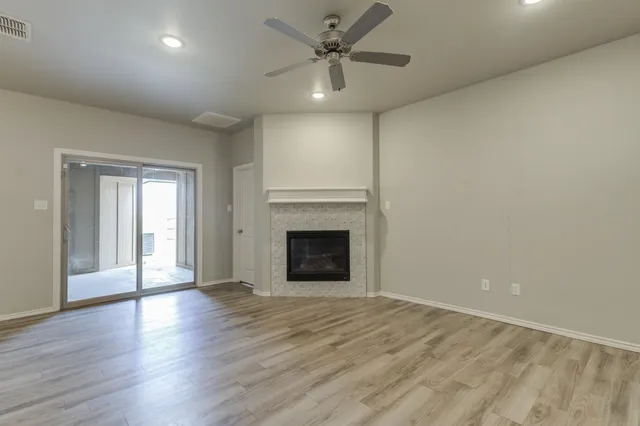a view of an empty room with a fireplace and a window