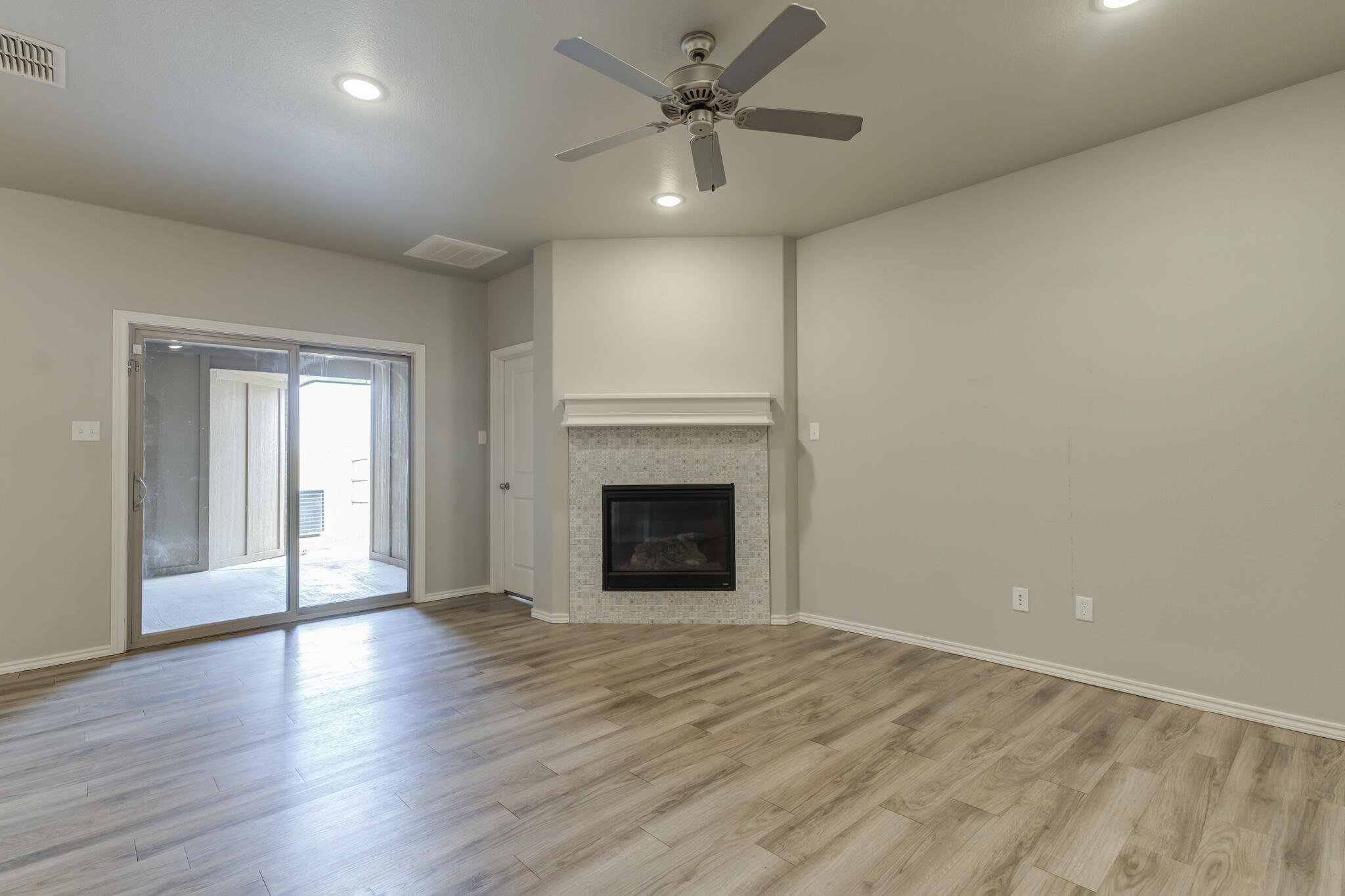 6906 67th Street Lubbock, TX 79424 - Photo 15 of 35 a view of an empty room with a fireplace and a window