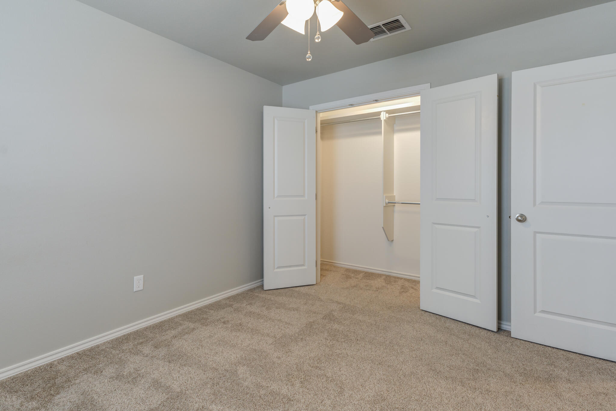 6906 67th Street Lubbock, TX 79424 - Photo 17 of 35 an empty room with a chandelier fan and closet area