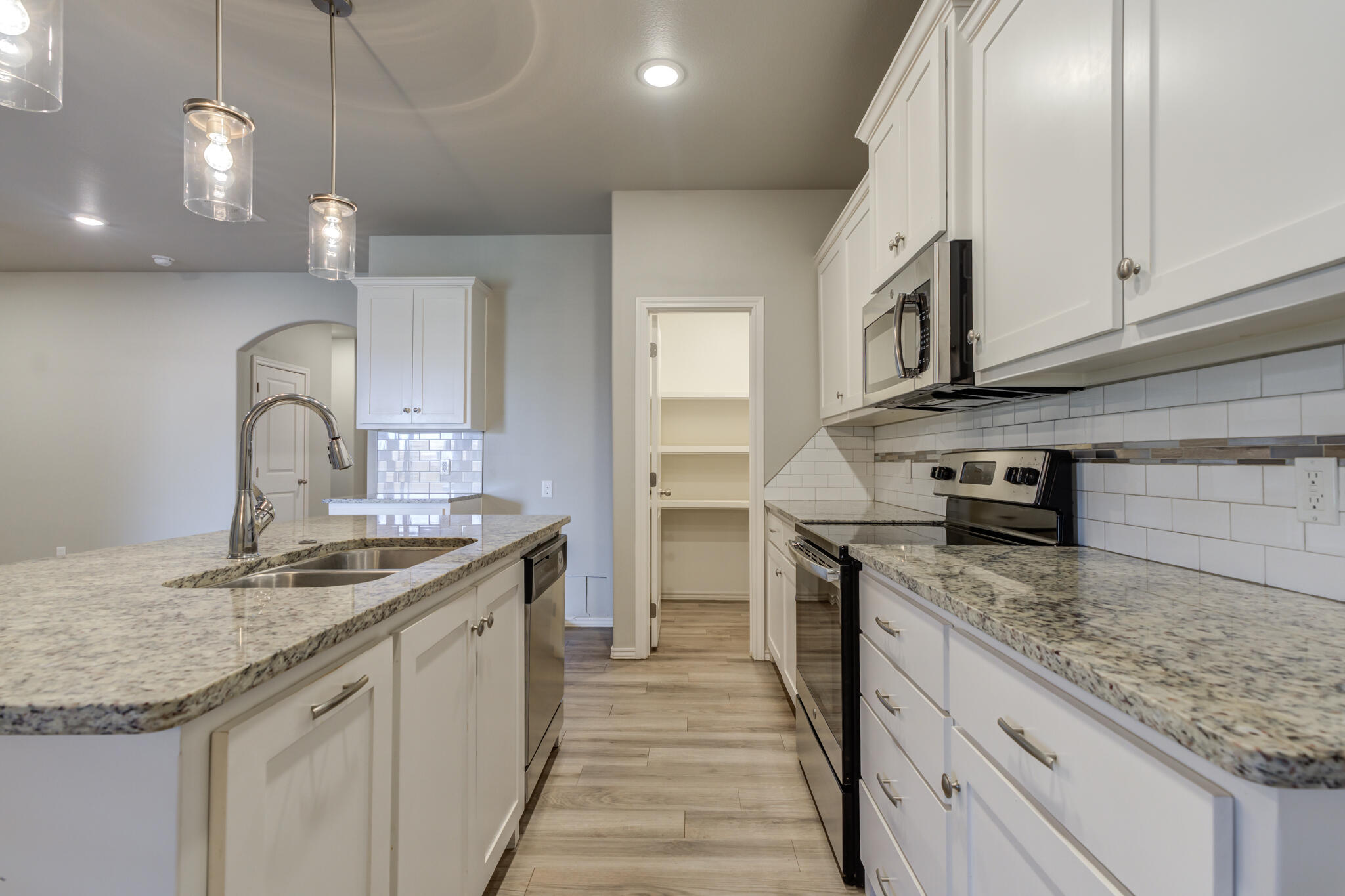 6906 67th Street Lubbock, TX 79424 - Photo 6 of 35 a kitchen with stainless steel appliances granite countertop a sink stove and cabinets