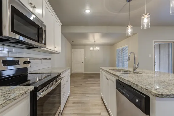 a kitchen with stainless steel appliances granite countertop a sink and stove