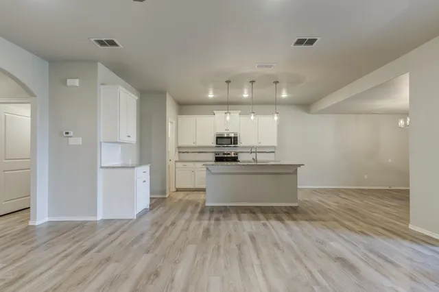 a large kitchen with a lot of counter space and stainless steel appliances