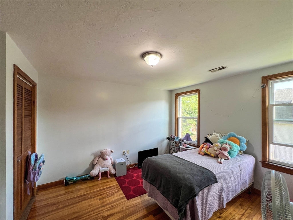 57 Vale Street Worcester, MA 01604 - Photo 26 of 42 a bedroom with a bed and wooden floor