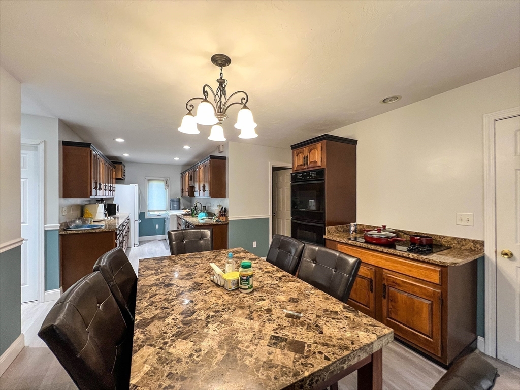 57 Vale Street Worcester, MA 01604 - Photo 27 of 42 a kitchen with a stove a refrigerator and a dining table