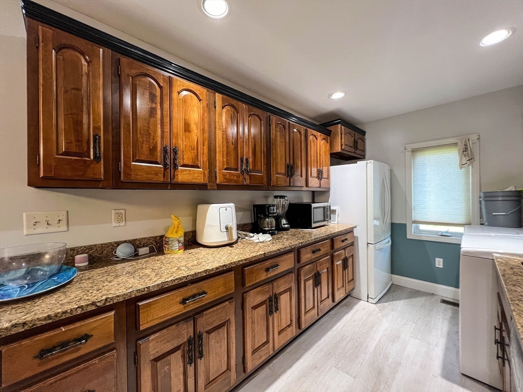 57 Vale Street Worcester, MA 01604 - Photo 28 of 42 a kitchen with stainless steel appliances granite countertop a refrigerator and wooden cabinets
