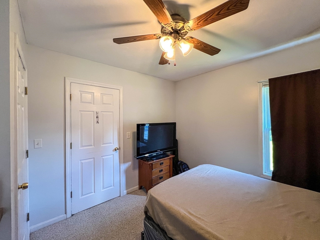 57 Vale Street Worcester, MA 01604 - Photo 35 of 42 a bedroom with a bed and a flat tv screen on wall