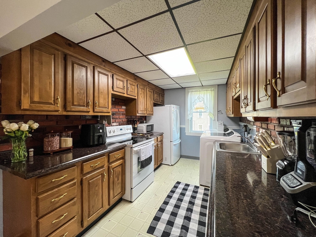 57 Vale Street Worcester, MA 01604 - Photo 6 of 42 a kitchen with stainless steel appliances granite countertop a stove a sink dishwasher and cabinets with wooden floor