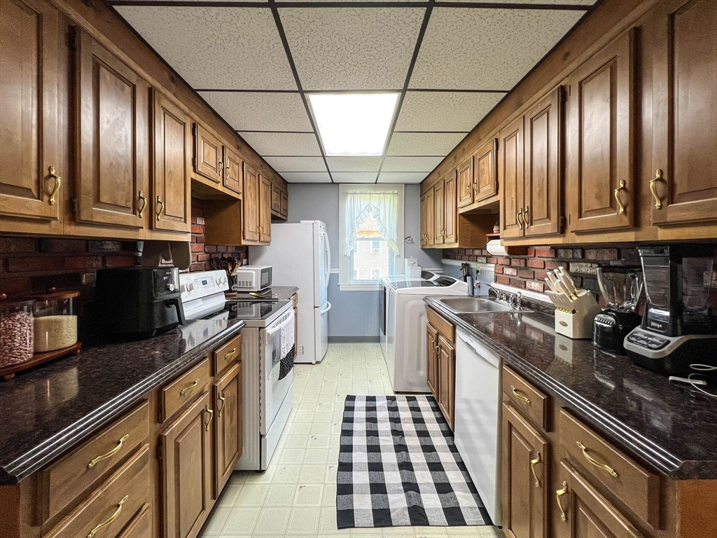 57 Vale Street Worcester, MA 01604 - Photo 7 of 42 a kitchen with stainless steel appliances granite countertop a stove a sink dishwasher a refrigerator and cabinets with wooden floor