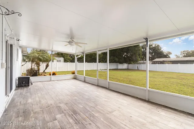 a view of an empty room with wooden floor and a floor to ceiling window