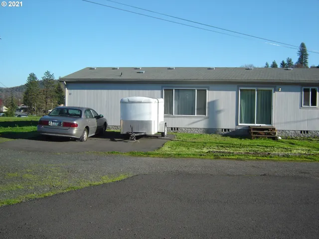 a front view of a house with a garden and plants