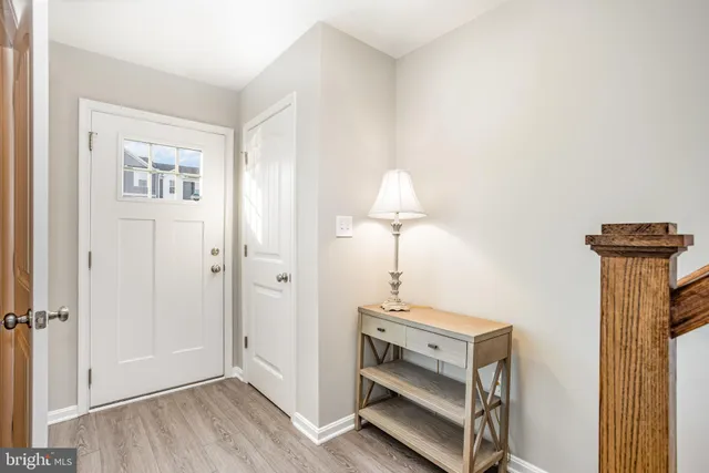 a view of a hallway with entryway and wooden floor