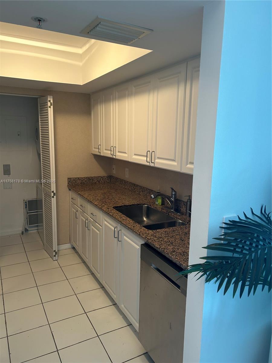 90 Alton Road, Unit 607 Miami Beach, FL 33139 - Photo 6 of 14 a kitchen with a sink and cabinets