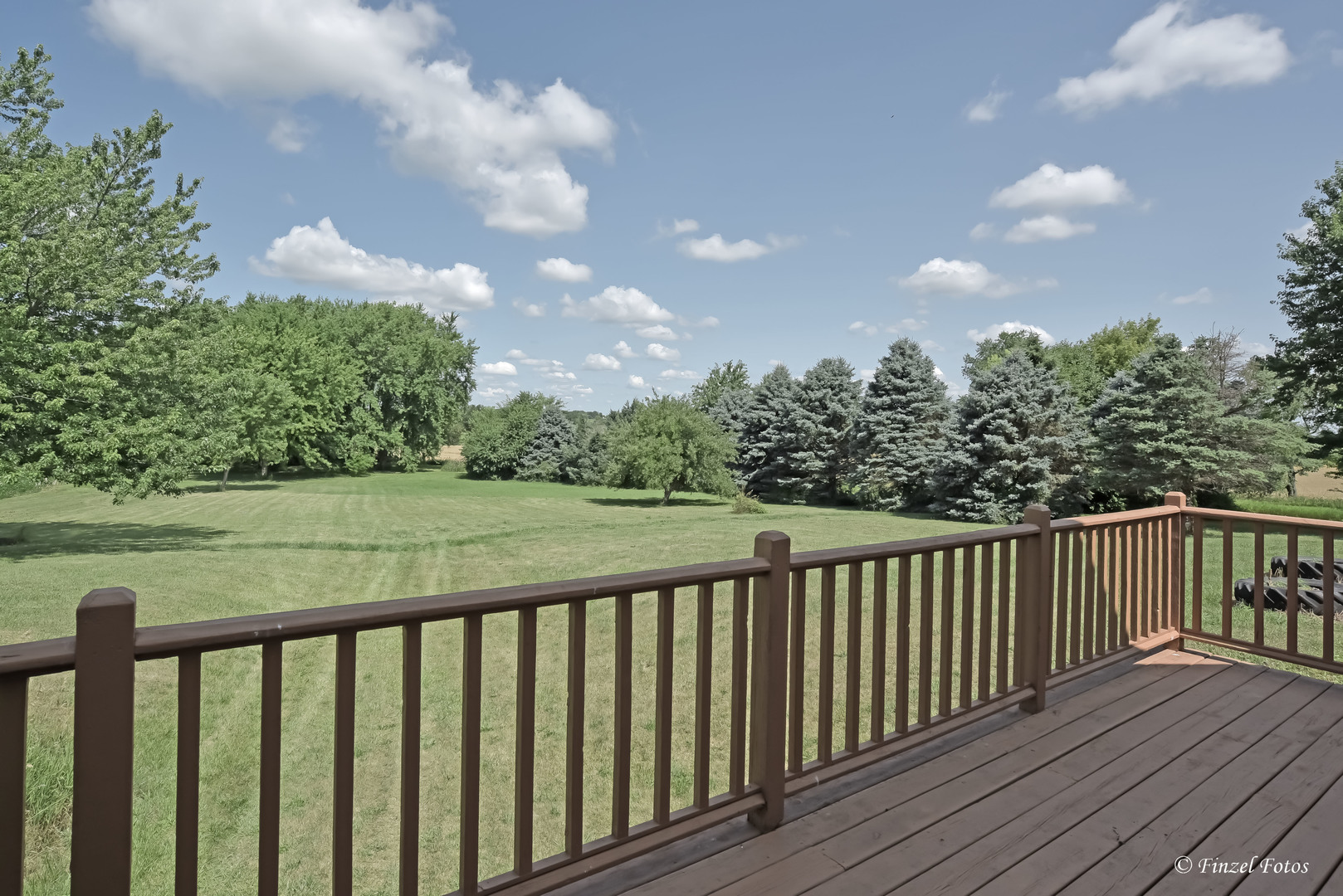23504 Flat Iron Road Harvard, IL 60033 - Photo 12 of 27 a balcony with wooden floor and trees in the back