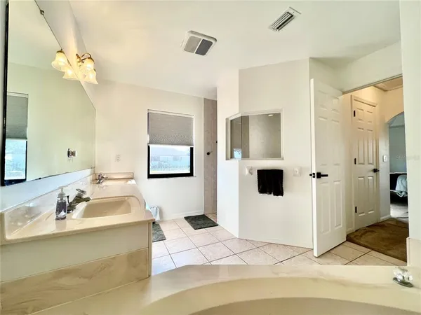 a bathroom with a tub shower and sink