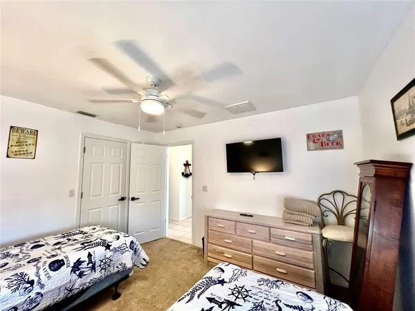 a spacious bedroom with two bed and a tv