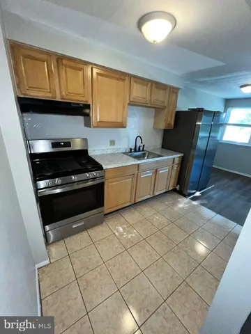a kitchen with granite countertop a stove a sink and a microwave
