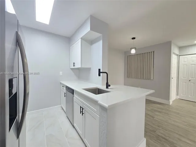 a kitchen with stainless steel appliances a sink and a refrigerator