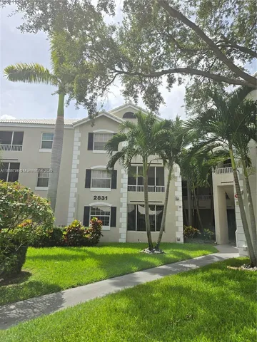 a front view of a house with a yard and green space
