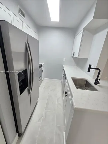 a view of a kitchen with a sink washer and dryer