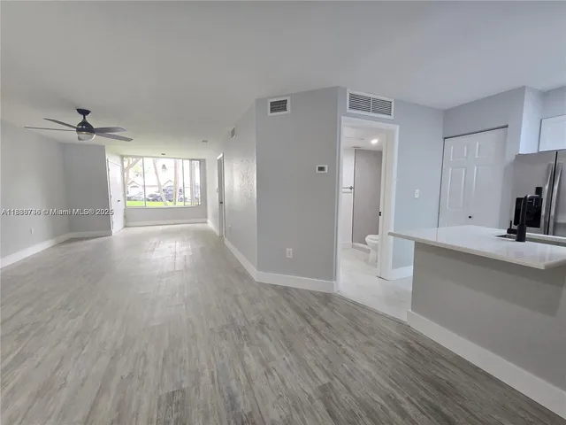 a view of a kitchen with a sink and wooden floor