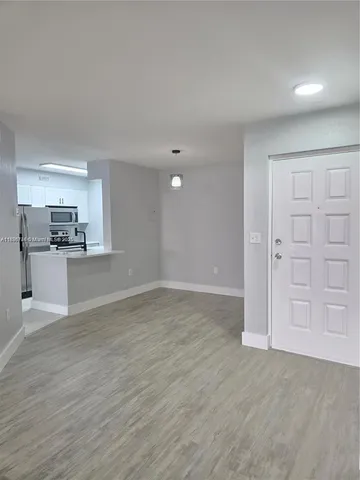 a view of a kitchen with a sink and a refrigerator