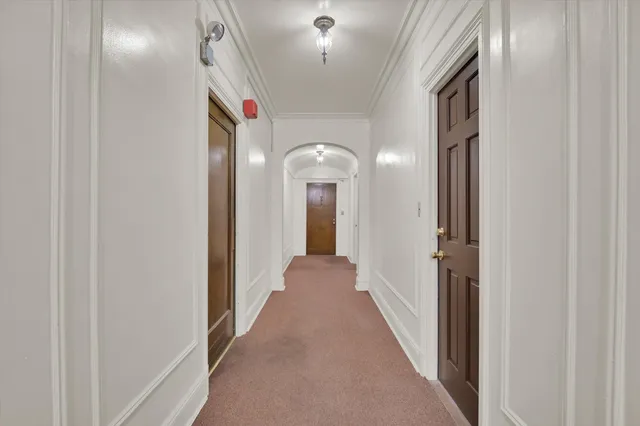 a view of a hallway with wooden floor and cabinet