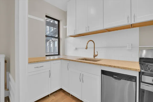 a kitchen with granite countertop white cabinets and a stove