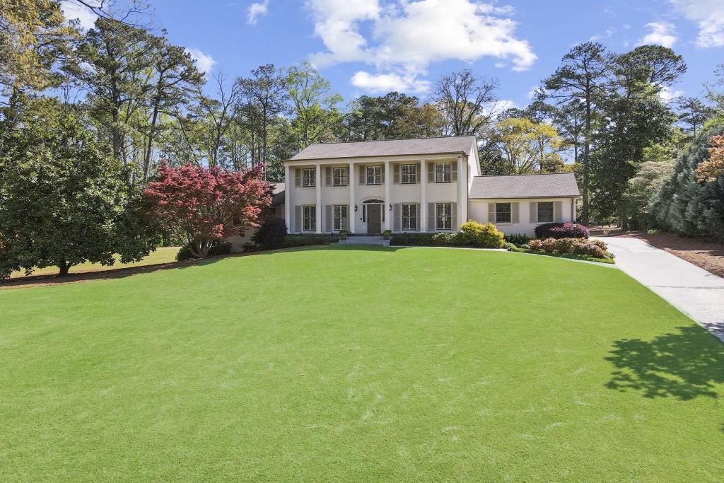 6035 Riverside Drive Sandy Springs, GA 30328 - Photo 1 of 1 a view of a house next to a big yard and large trees