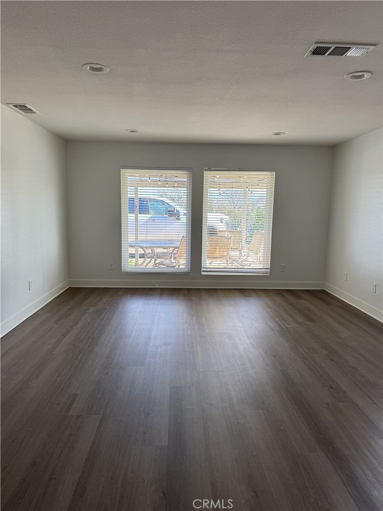 15521 Saddleback Road Woodcrest, CA 92506 - Photo 14 of 24 an empty room with wooden floor and windows