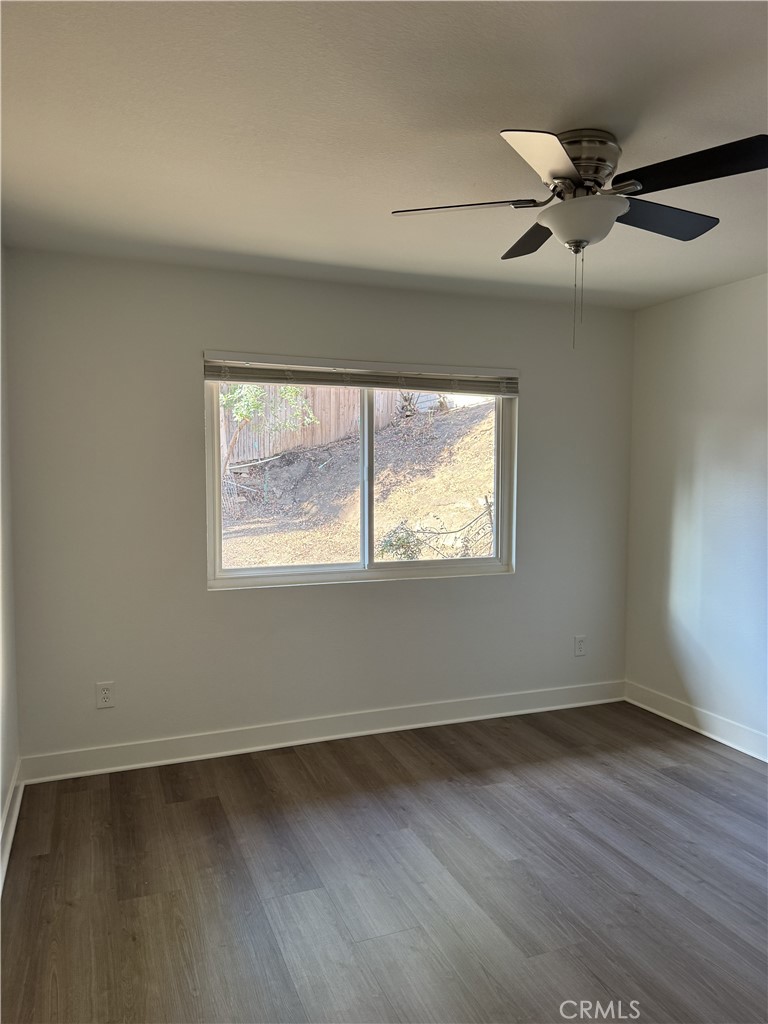 15521 Saddleback Road Woodcrest, CA 92506 - Photo 20 of 24 an empty room with wooden floor fan and windows