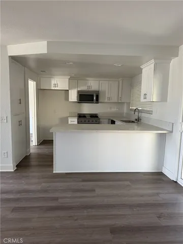 a view of kitchen with stainless steel appliances granite countertop a stove a sink and a refrigerator