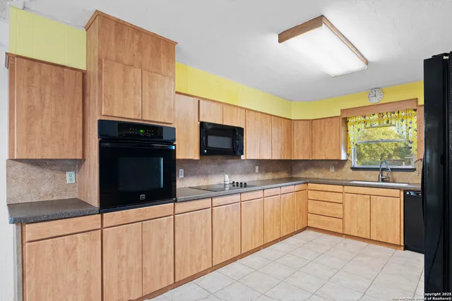 a kitchen with a sink a window and cabinets