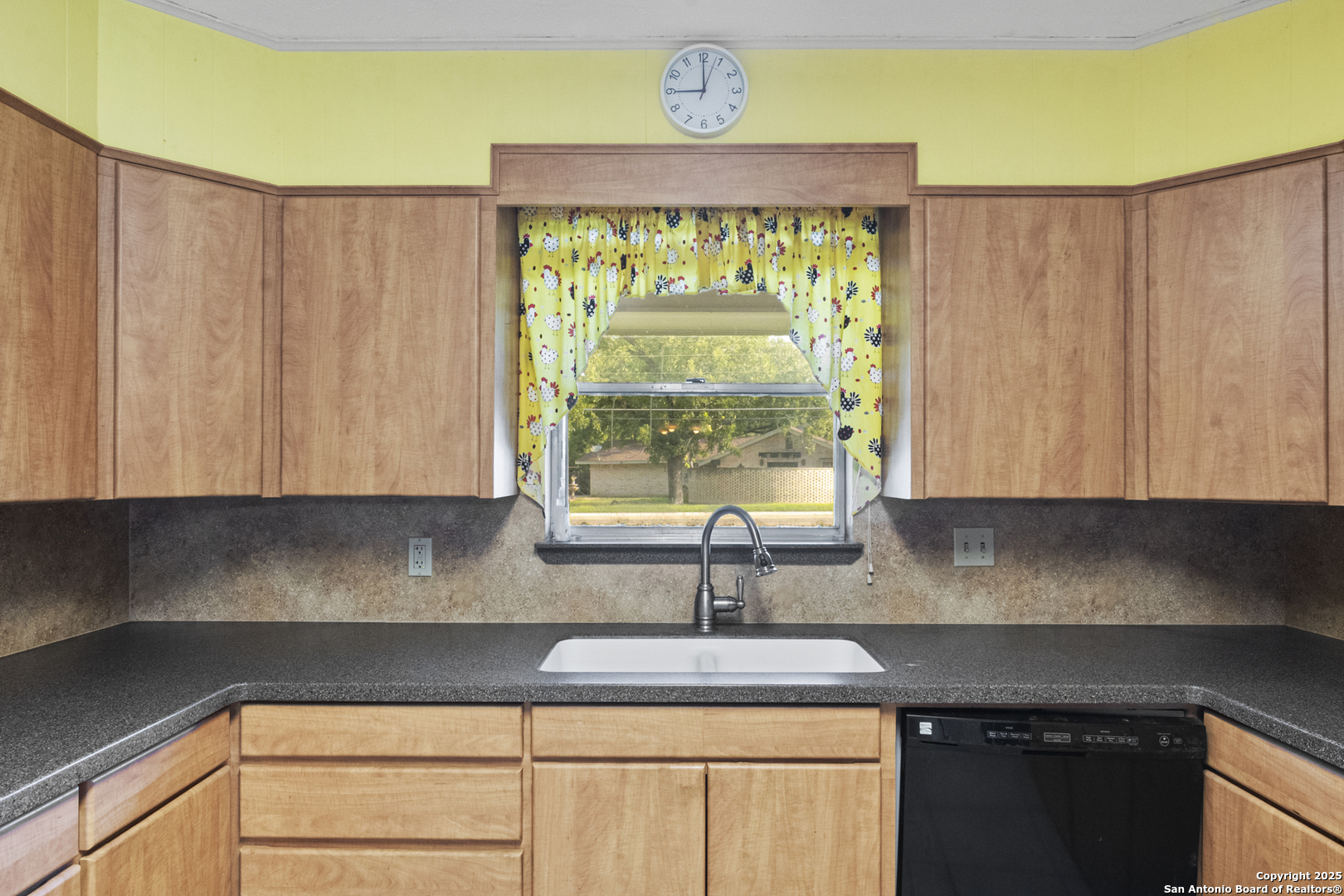 715 Studer Street Uvalde, TX 78801 - Photo 12 of 44 a kitchen with a sink a window and cabinets