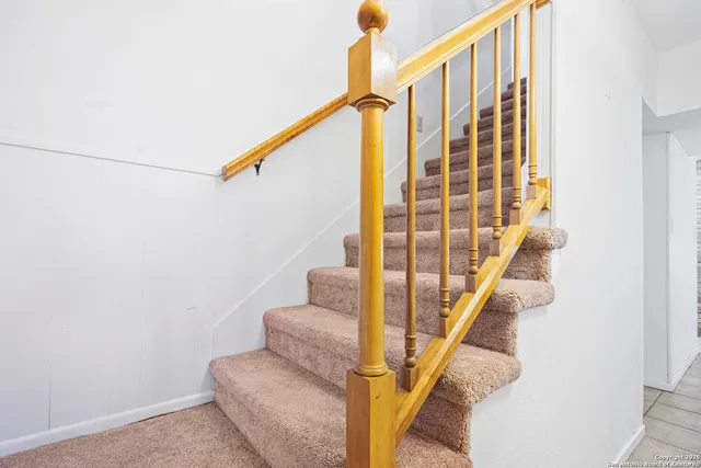 a bed sitting in a bedroom next to a window and a chandelier