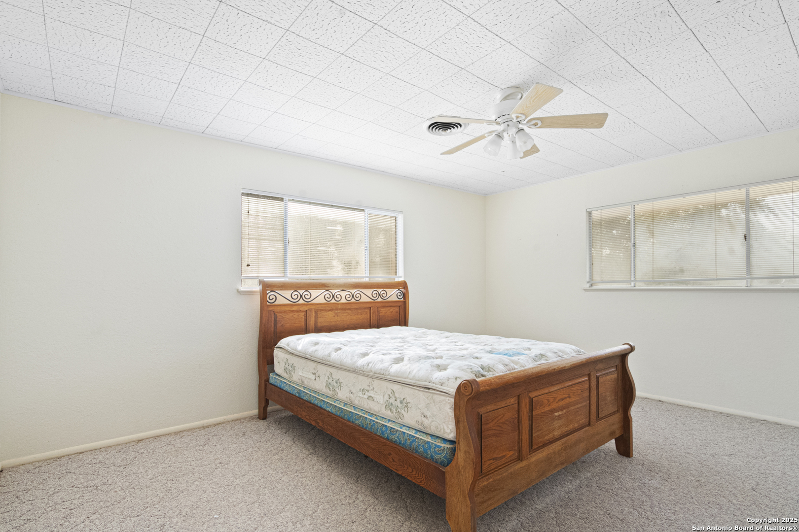 715 Studer Street Uvalde, TX 78801 - Photo 24 of 44 a bed sitting in a bedroom next to a window and a chandelier