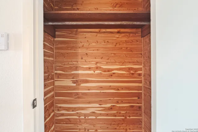 a view of an empty room with a window and a ceiling fan