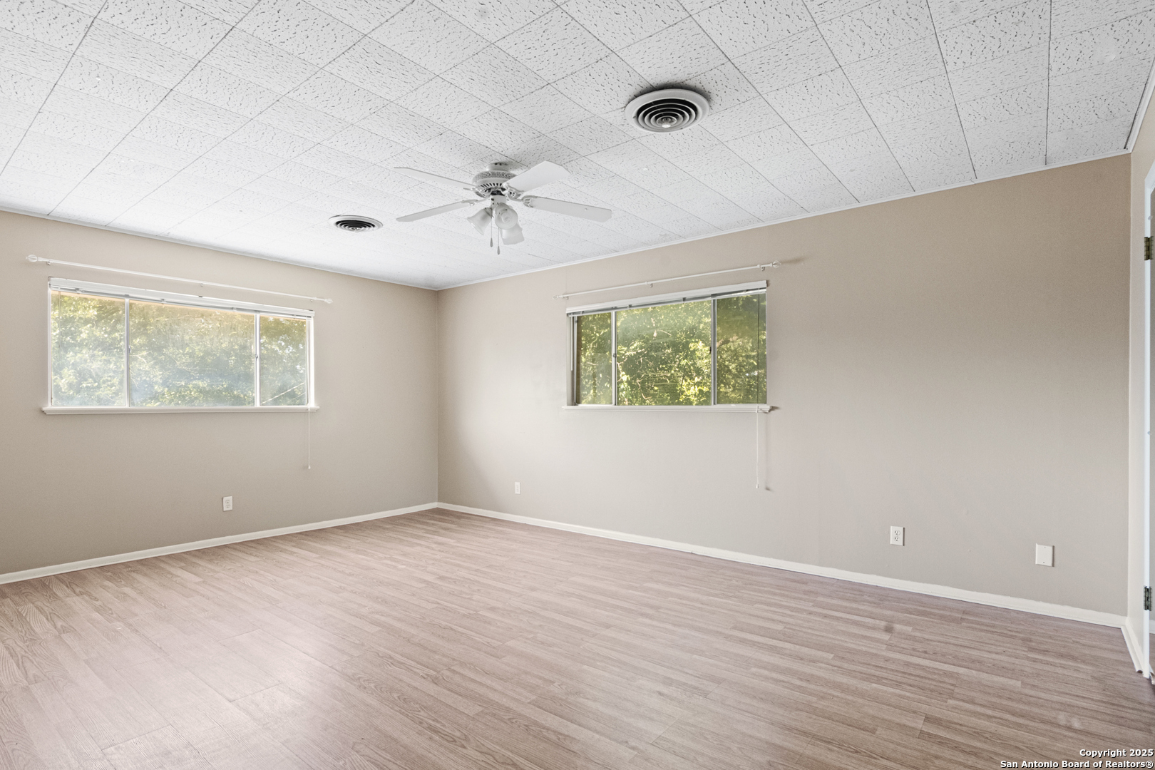 715 Studer Street Uvalde, TX 78801 - Photo 31 of 44 a view of an empty room with a window and a ceiling fan