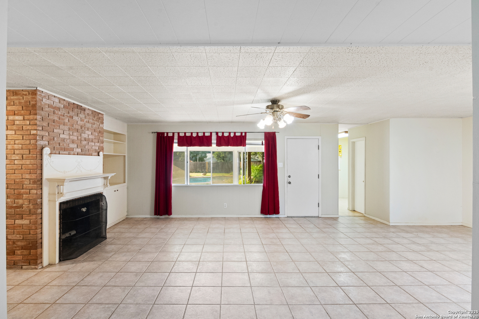 715 Studer Street Uvalde, TX 78801 - Photo 8 of 44 an empty room with windows and fireplace