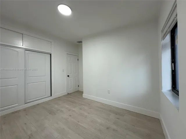 a view of a room with wooden floor and windows