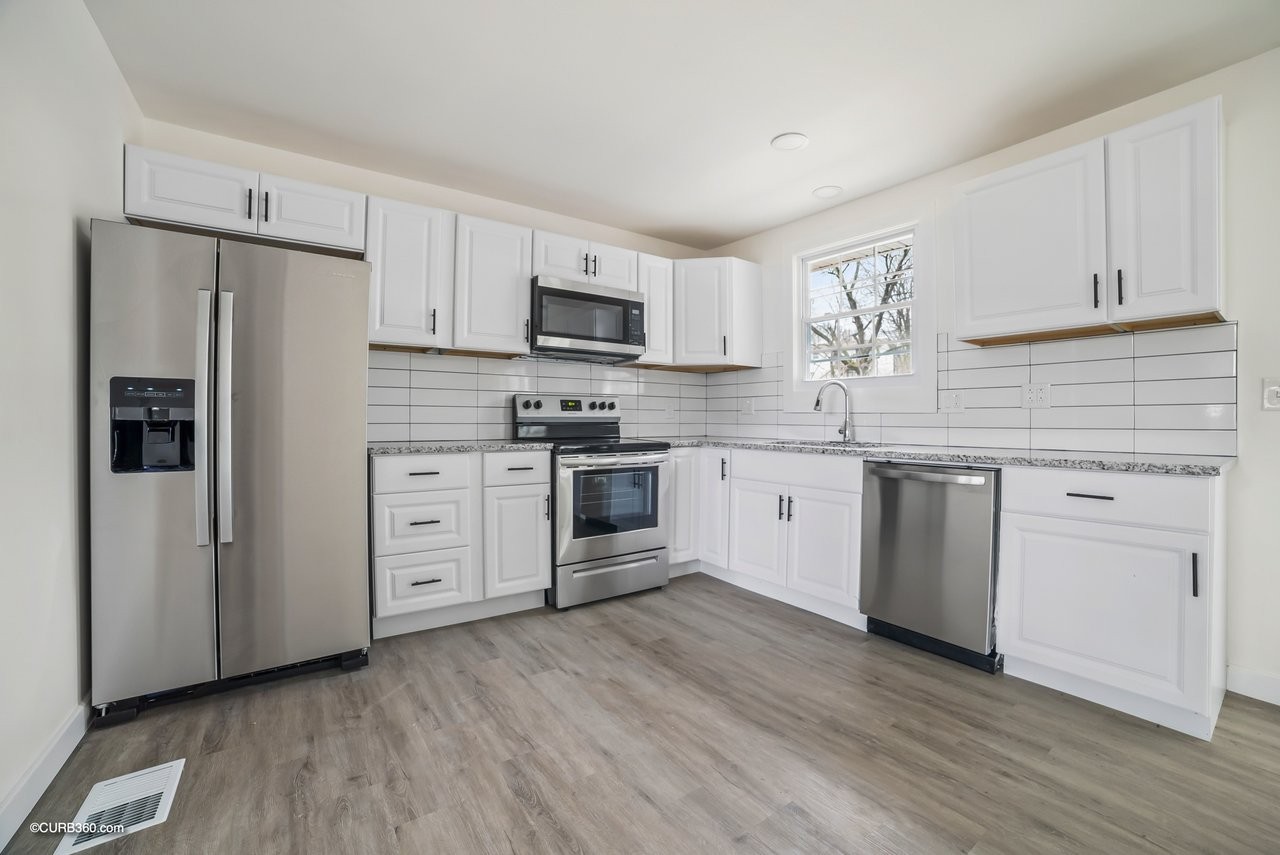491 Rural Hill Road Nashville, TN 37217 - Photo 6 of 32 a kitchen with white cabinets and stainless steel appliances