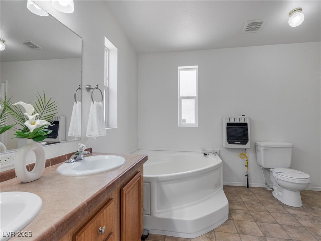 70 West Bonanza Road Las Vegas, NV 89124 - Photo 28 of 71 Bathroom featuring heating unit, a bath, double vanity, toilet, and baseboards