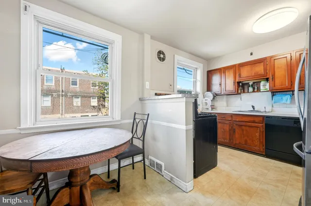 a kitchen with a table chairs refrigerator and window