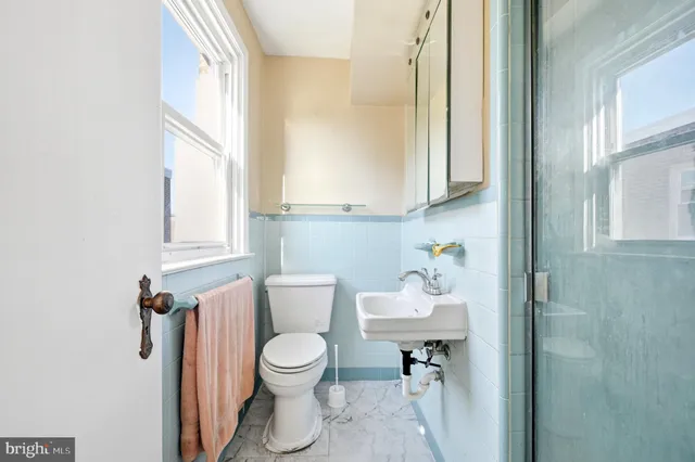 a bathroom with a toilet sink and mirror