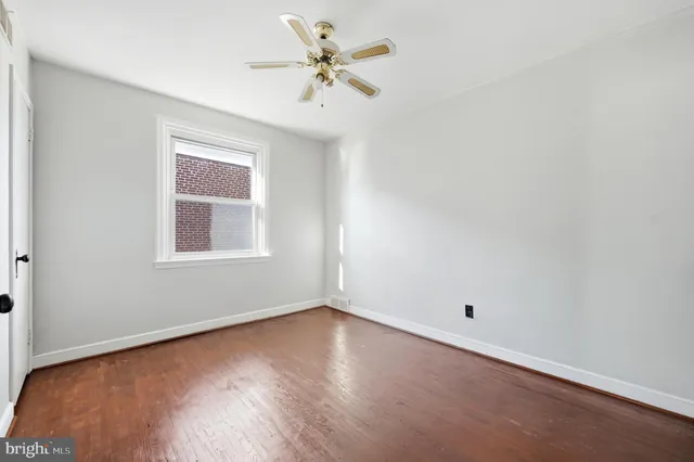 an empty room with a window and a fan