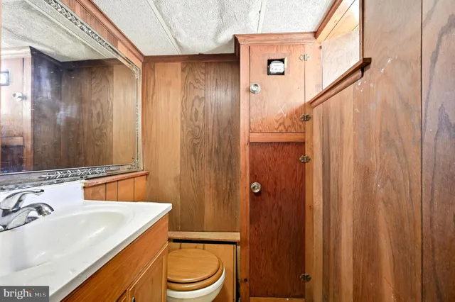 a bathroom with a sink a toilet a mirror and shower