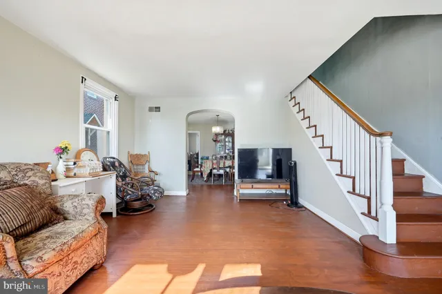 a living room with furniture and a dining table with wooden floor