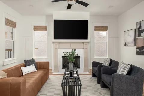 a living room with furniture a flat screen tv and a fireplace