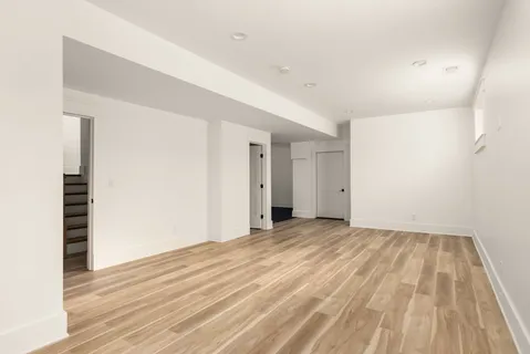 a view of an empty room with wooden floor