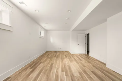 a view of an empty room with wooden floor
