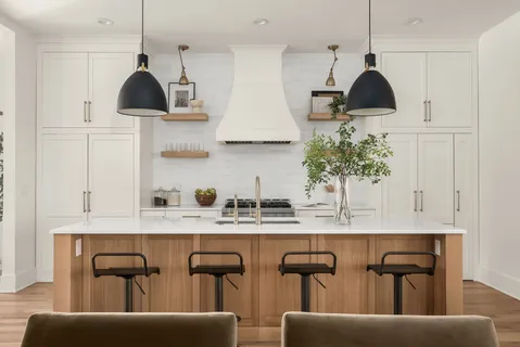 a kitchen with stainless steel appliances granite countertop a sink a stove and a dining table with wooden floor
